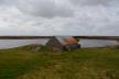 Stone and corrugated metal of an outhouse by the lake behind Moss Cottage